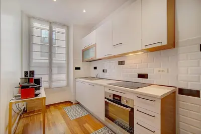 a kitchen with white cabinets and a window at REF 1320 - Cannes Center - Apartment for rent in Cannes