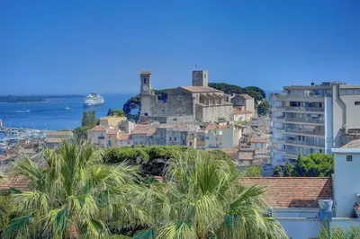 a city with a castle on a hill with palm trees at Modern 2 Bd Next To Rue Dantibes in Cannes