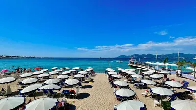a bunch of umbrellas on a beach with the ocean at Modern 2 Bd Next To Rue Dantibes in Cannes