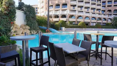 a row of tables and chairs next to a swimming pool at Appartement 753, 4 personnes, vue mer By Palmazur in Cannes