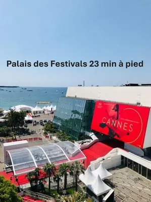 a building with a coca cola sign next to the beach at Beau 2 chambres TERRASSE, JARDIN, Picaud- Proche Plages MIDI A2B241 in Cannes