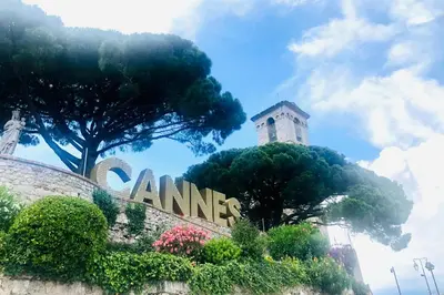 a sign in front of a building with trees and a tower at Cannes Heart of town 2 BR perfect congress & Holidays by Olam Properties in Cannes