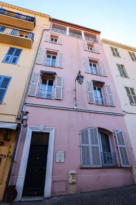 a pink building with windows and a door at IMMOGROOM - Beautiful and Cosy - Air conditioner - 5 min from beaches in Cannes