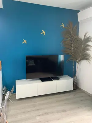 a blue room with a white cabinet and a blue wall at Appartement Etat neuf La Chantalane -proche centre-ville in Cannes