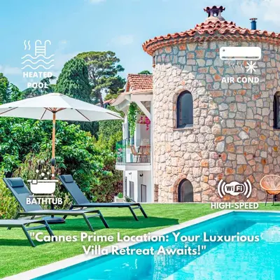 a pair of lounge chairs and an umbrella next to a house at Villa Quartier Oxford garden & pool in Cannes AC in Cannes